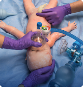Providers practice palpating an umbilical pulse and using a T-piece resuscitator on the SUPER TORY patient simulator.